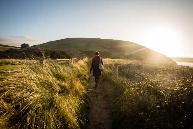 girl-walking-on-a-coastal-path-filled-with-light-2024-10-31-19-53-59-utc-aspect-ratio-700-525